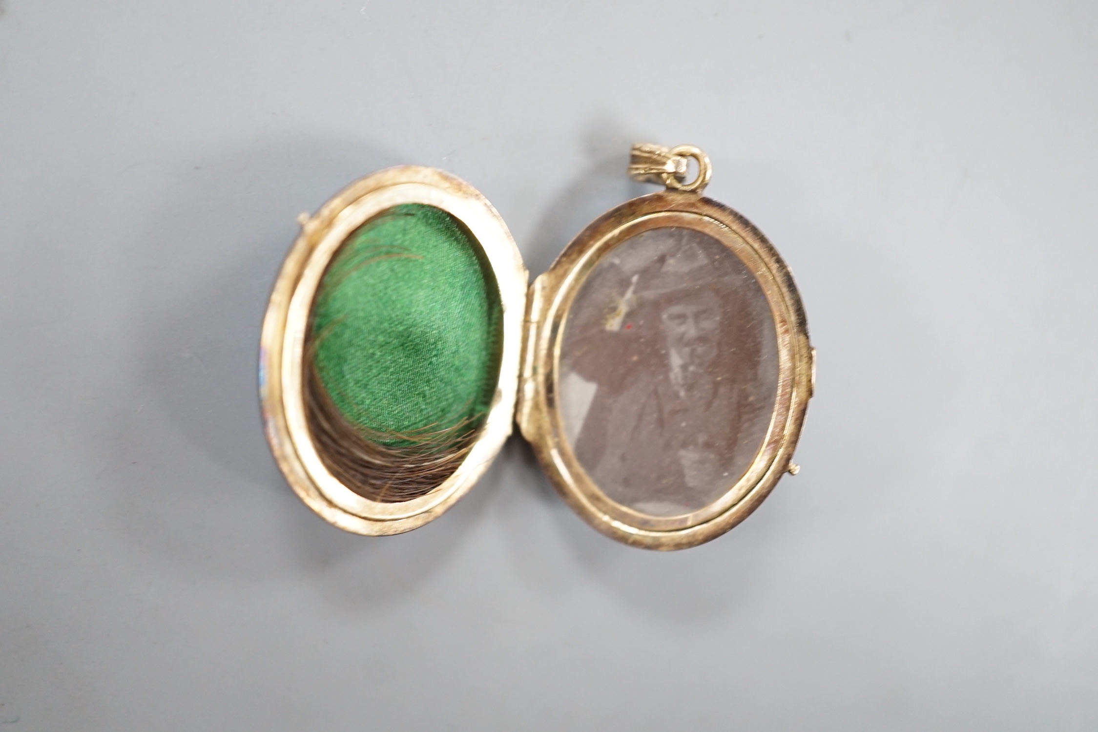 A 19th century yellow metal miniature oval portrait mourning brooch, 54mm, two enamelled lockets(a.f.) and one other small pendant.